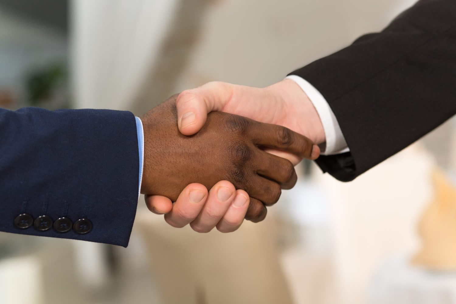 Close-up portrait of business people shaking hands. People showing mutual agreement betweent their companies or enterprises.